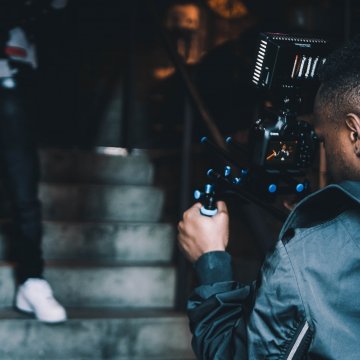 a person taking a recording at an event on steps